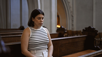 Young beautiful hispanic woman sitting on a church bench at Augustinian Church in Vienna