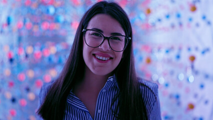Young beautiful hispanic woman visiting futuristic exhibition space