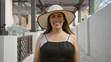 A smiling young adult hispanic woman wearing a sunhat in the traditional souk madinat jumeirah, dubai. - Powered by Adobe