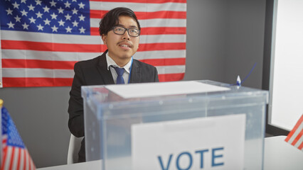 A young asian man in a suit voting at a us electoral college with an american flag backdrop.