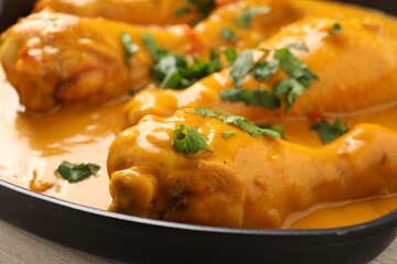 Tasty chicken curry with parsley on wooden table, closeup