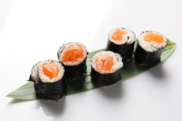 Delicious sushi rolls with salmon on white background