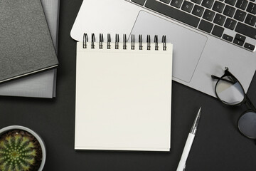 Flat lay composition with notebooks and laptop on black table