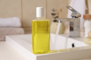 Fresh mouthwash in bottle on sink in bathroom, closeup