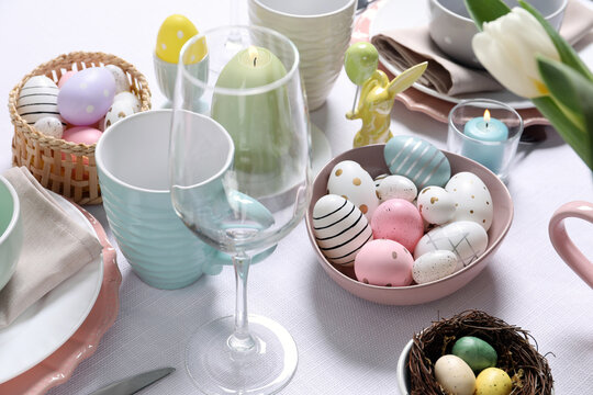 Festive table setting with painted eggs, closeup. Easter celebration