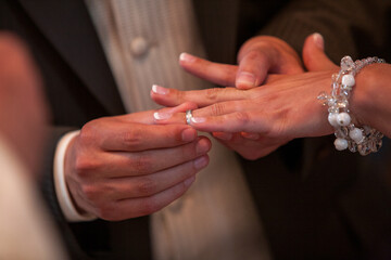 This photograph captures a poignant moment within a wedding ceremony: the gentle placement of a...