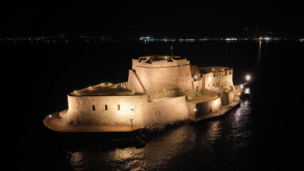 Aerial drone night shot of illuminated castle of Bourtzi built at sea a popular attraction in city...