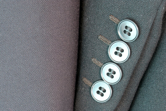 Close up of jacket sleeves with four buttons on the cuff.