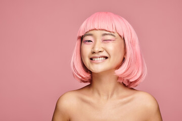 attractive asian woman with nose piercing and pink hair winking on vibrant background