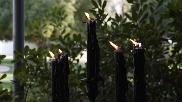 Mystical Arrangement. Row of Illuminated Black Candles in Shadowy Ambiance. Intriguing Composition Evoking Mystery and Enigma. Perfect for Halloween, Gothic, or Occult Concepts in Design Creativity.