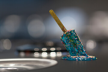 Close up on a melted popsicle on the iron table of a ice cream maker. - 764998399
