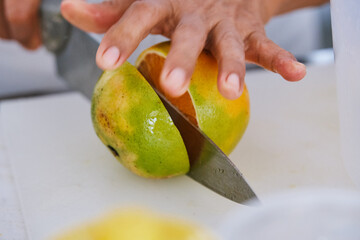 Mano cortando una naranja con un cuchillo
