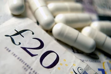 Gartenposter Currency and pills. UK pounds bank notes. © Richard