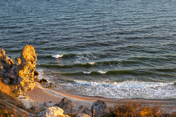Seascape. Rocky seashore with a foamy wave, view from the mountain. Travel and tourism.