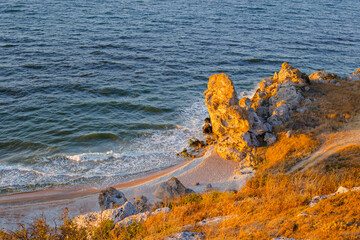 Bright landscape. Sea with waves and rocky coast of Crimea in the evening. Travel and tourism.