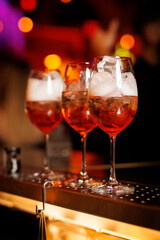 Aperol spritz cocktail in tulip glass on a bar counter.