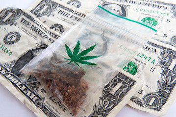General stock - US bank notes with a plastic bag with a marijuana symbol containing some Thai weed bought from an Amsterdam coffee shop.