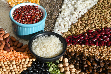 Bowl with raw white rices and beans on various seeds grain