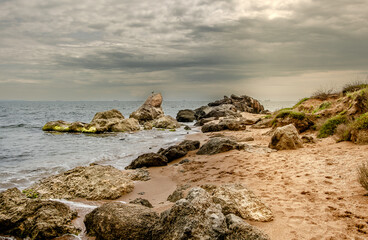 A sandy beach with rocks near the sea.
