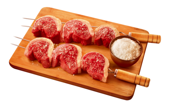 espeto com pedaços de picanha crua sobre tábua de madeira acompanhado de pote com sal grosso isolado em fundo transparente