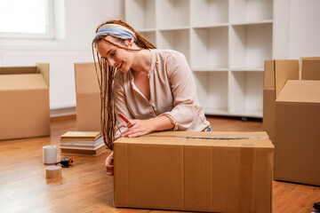 Modern ginger woman with braids moving into new home.	 - 765026184