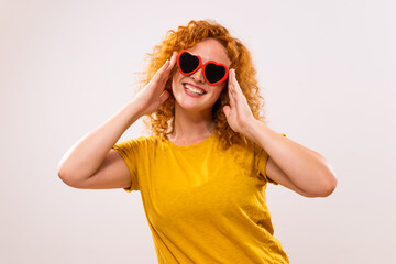 Image of happy ginger woman with red heart shaped sunglasses.	 - 765026332
