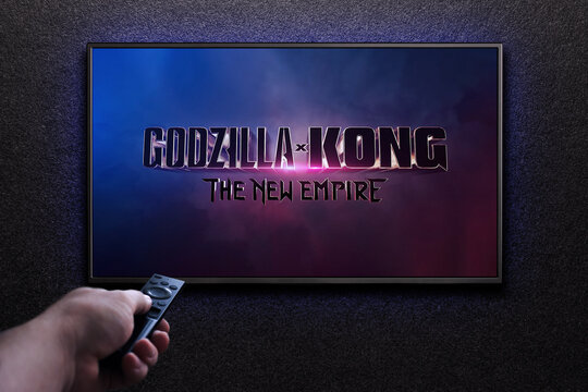 Godzilla x Kong The New Empire trailer or movie on TV screen. Man turns on TV with remote control. Astana, Kazakhstan - March 22, 2024.