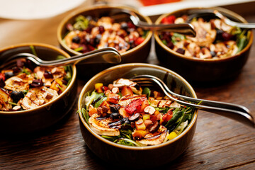The spread of gourmet salads with grilled vegetables, tender chicken pieces, and a sprinkle of nuts