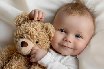 A baby is holding a teddy bear and smiling