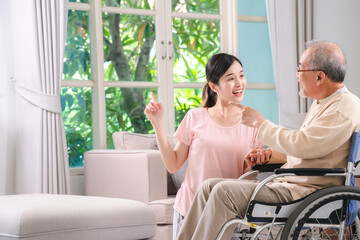 Celebrating Father's Day, Senior Asian grandfather in a wheelchair shares a happy moment at home, hugging his family together, symbolizing generational love and care, health care and life insurance - 765031901