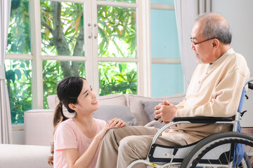Celebrating Father's Day, Senior Asian grandfather in a wheelchair shares a happy moment at home, hugging his family together, symbolizing generational love and care, health care and life insurance - 765031907