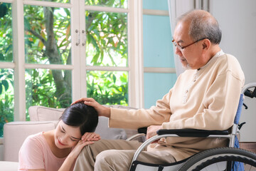 Celebrating Father's Day, Senior Asian grandfather in a wheelchair shares a happy moment at home, hugging his family together, symbolizing generational love and care, health care and life insurance - 765031919