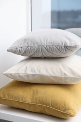 Fototapeta na wymiar Stack of soft pillows on window sill indoors