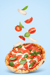 Caprese pizza and ingredients in air on light blue background