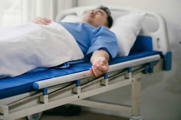 A man is laying in a hospital bed with his arm outstretched