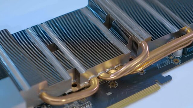 Powerful radiator with copper tubes for circulating coolant to cool the computer video card. Closeup. Macro. Shallow depth of field. Shot in motion