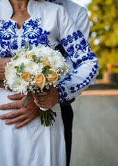 The bride and groom hold a wedding bouquet	