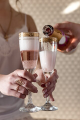 A woman holds glasses into which a man pours champagne	
