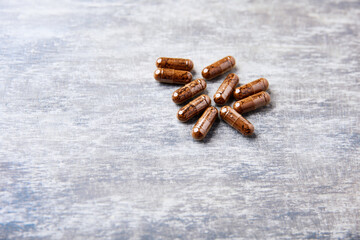 Korean Ginseng capsules. Concept for a healthy dietary supplementation. Bright wooden background. Copy space.