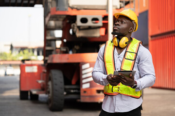 Portrait African logistic engineer man worker or foreman working with forklift container background at container site	 - 765060315