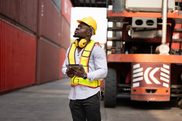 Portrait African logistic engineer man worker or foreman working with forklift container background at container site	 - 765060330