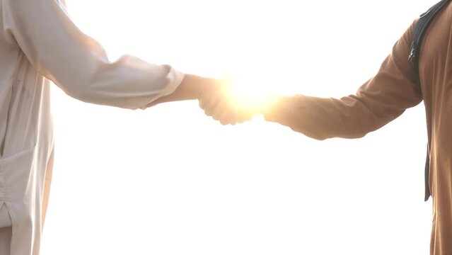 Successful business people handshaking. Two businessmen shaking hands of each other with sunset at background. slow motion. Young colleagues meeting and shaking hands on sunset.