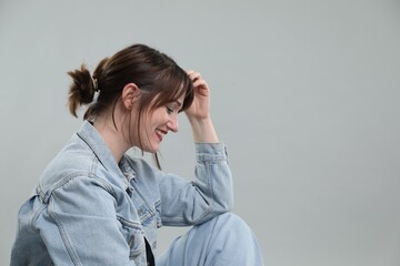 Portrait of happy woman on grey background