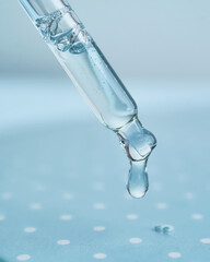 Pipette with serum on a blue background.