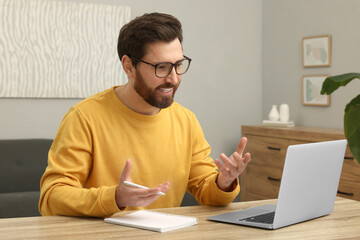 Man having video chat via laptop at home