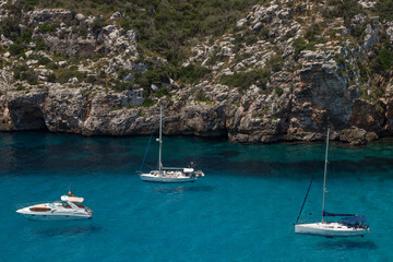 Fototapeta na wymiar Recreational boats in the natural bay near the Spanish village of Cala en Porter on Menorca.
