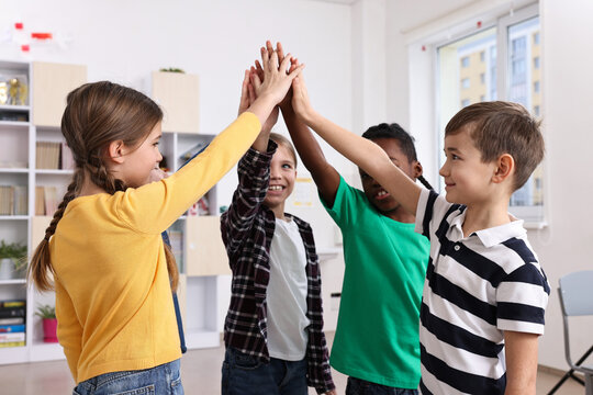 Happy children giving high five at school