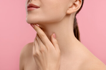 Obraz na płótnie Canvas Woman touching her chin on pink background, closeup
