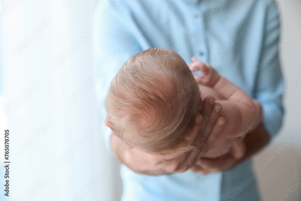 Wall mural Father holding his newborn baby at home, closeup