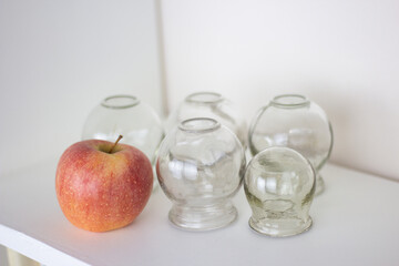 Glass jars for hijama and apple on a white background. Bloodletting. Sunnah treatment. Islam.